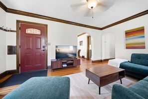 A modern living room with a television, sofa, and coffee table. - MINNeSTAY* Magnolia House (Minneapolis)