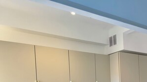 Eine moderne Küche mit eingebautem Backofen, einem Waschbecken mit goldenem Wasserhahn und hellen Schränken.