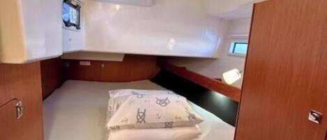 A compact cabin with a bed, a bench, and a small seating area.