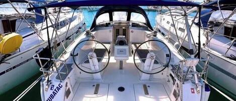 A boat deck with a steering wheel, control panel, and 'ZUBATAC' label.