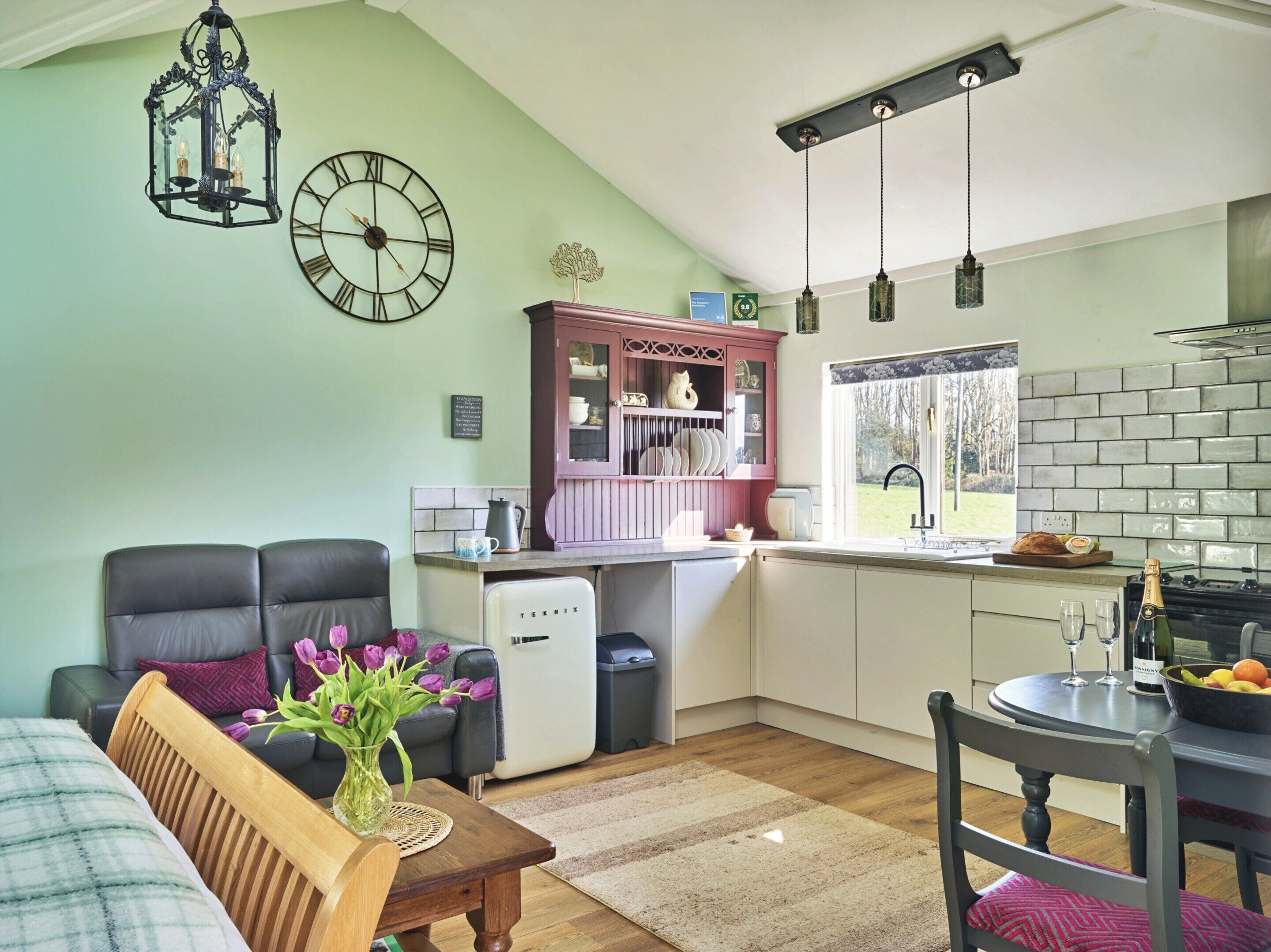 A compact living space with a kitchenette, a dining area, and a seating area with a sofa and a table.
