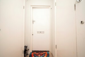 Uma porta branca com placa de identificação e fechadura.