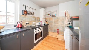 A modern kitchen with a built-in oven, a kettle, and a microwave. - Comfortable Stay in the Heart of Vibrant Deptford - Pass the Keys (London)