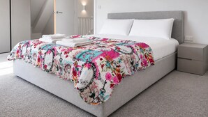 Ein modernes Schlafzimmer mit einem großen Bett, einem Nachttisch und einem Kleiderschrank.