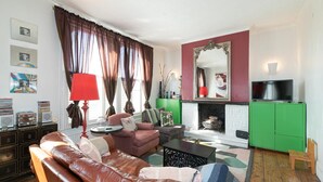 A living room with a leather sofa, a coffee table, a fireplace, a television, and a green cabinet. - Charming Victorian House, Selhurst Park, London - Pass the Keys (London)