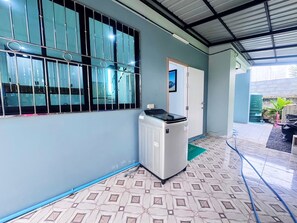 A room with a patterned floor, a radiator, a window with metal bars, and a door. - Ao nang Private Rooftop Poolvilla (Tambon Ao Nang)