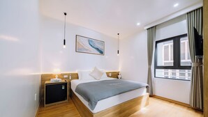 A modern hotel room with a wooden bed, a small bedside table, a flat-screen TV, and a window with curtains. - Minn Cat Ba (Hai Phong)
