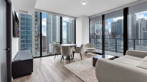 Ein modernes Wohnzimmer mit Essbereich, großen Fenstern und Blick auf die Stadt.