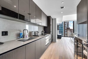 A modern kitchen with a large island, built-in appliances, and a view of the city. - Miami Pulse With Resort Amenities (Miami)