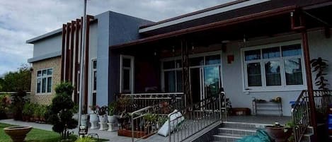 A building with a modern architectural style, featuring a flat roof, large windows, and a covered entrance with a staircase.