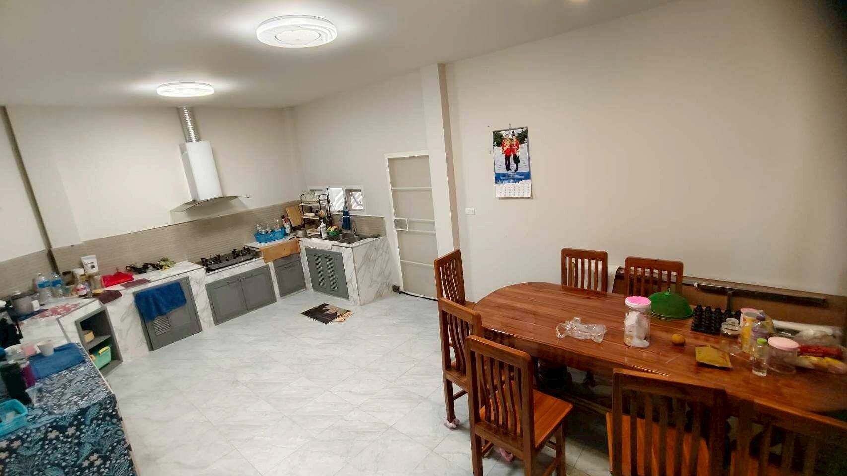 A compact kitchen with a dining area, a built-in oven, and a refrigerator.