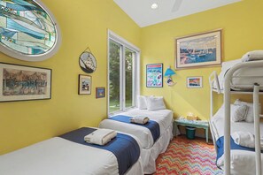 Una habitación con dos camas, una ventana y varias decoraciones en las paredes.