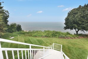 A staircase leading to a deck overlooking a body of water with a clear sky. - Sleepy Hollow Beach Resort, Villa E – Family Fun on Lake Michigan! (South Haven)