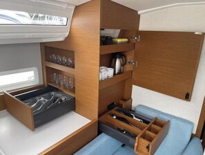 A compact interior with a bed, storage compartments, and a window. - Sun Odyssey 410 - Rosso Bianco (Marina Veruda)