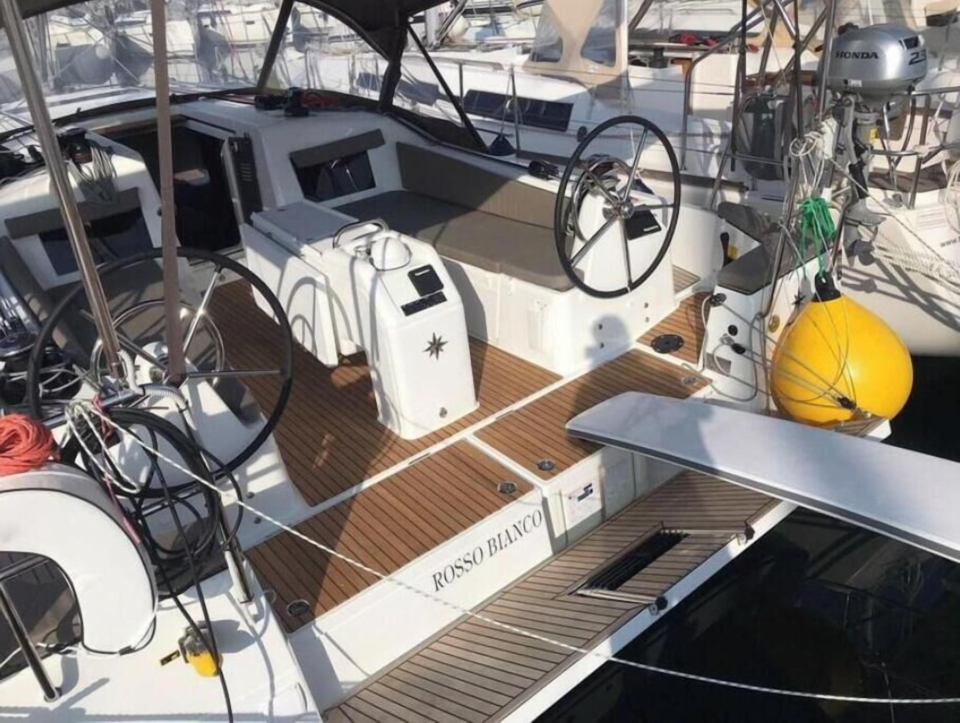 Ein Bootsdeck mit Steuer, Winschen und einer gelben Boje.