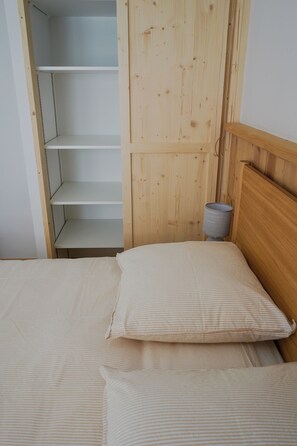 Una cama individual con dos almohadas y cabecera de madera.