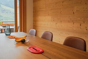 Ein Holztisch mit einer Glasvase, zwei Bananen und einer roten Unterlage.