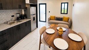 Eine moderne Küche mit dunklen Holzschränken, einem Edelstahlkühlschrank und einer Arbeitsplatte aus Granit.