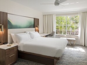 A hotel room with a bed, bedside table, chair, and a large window with curtains. - 3 Bedroom Villa at Lakeshore Reserve w/ Amenities (Orlando)