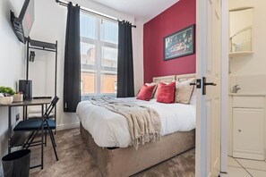 Ein Schlafzimmer mit einem Bett, einem Schreibtisch und einem Stuhl.