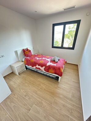 A bedroom with a bed, a nightstand, a window, and a view of greenery outside. - Large, air-conditioned family home with a pool in Toulon, Var (La Valette-du-Var)