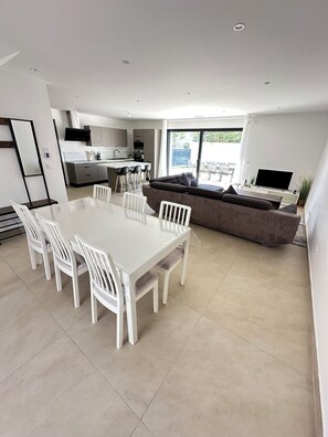 A modern kitchen with a dining area, a sofa, and a TV. - Large, air-conditioned family home with a pool in Toulon, Var (La Valette-du-Var)