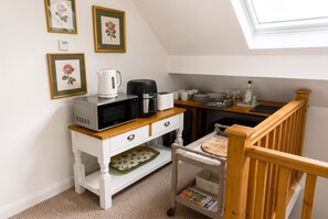 A kitchenette with a microwave, coffee maker, toaster, and a small table with a magazine. - Two bed apartment, sleeps 5, ideal for work and family stays (New Longton)