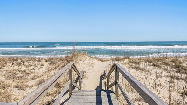 A wooden boardwalk leading to a beach with clear skies. - Making Memories: Oceanfront 6 BR | Hot Tub | Shared Pool (Duck)