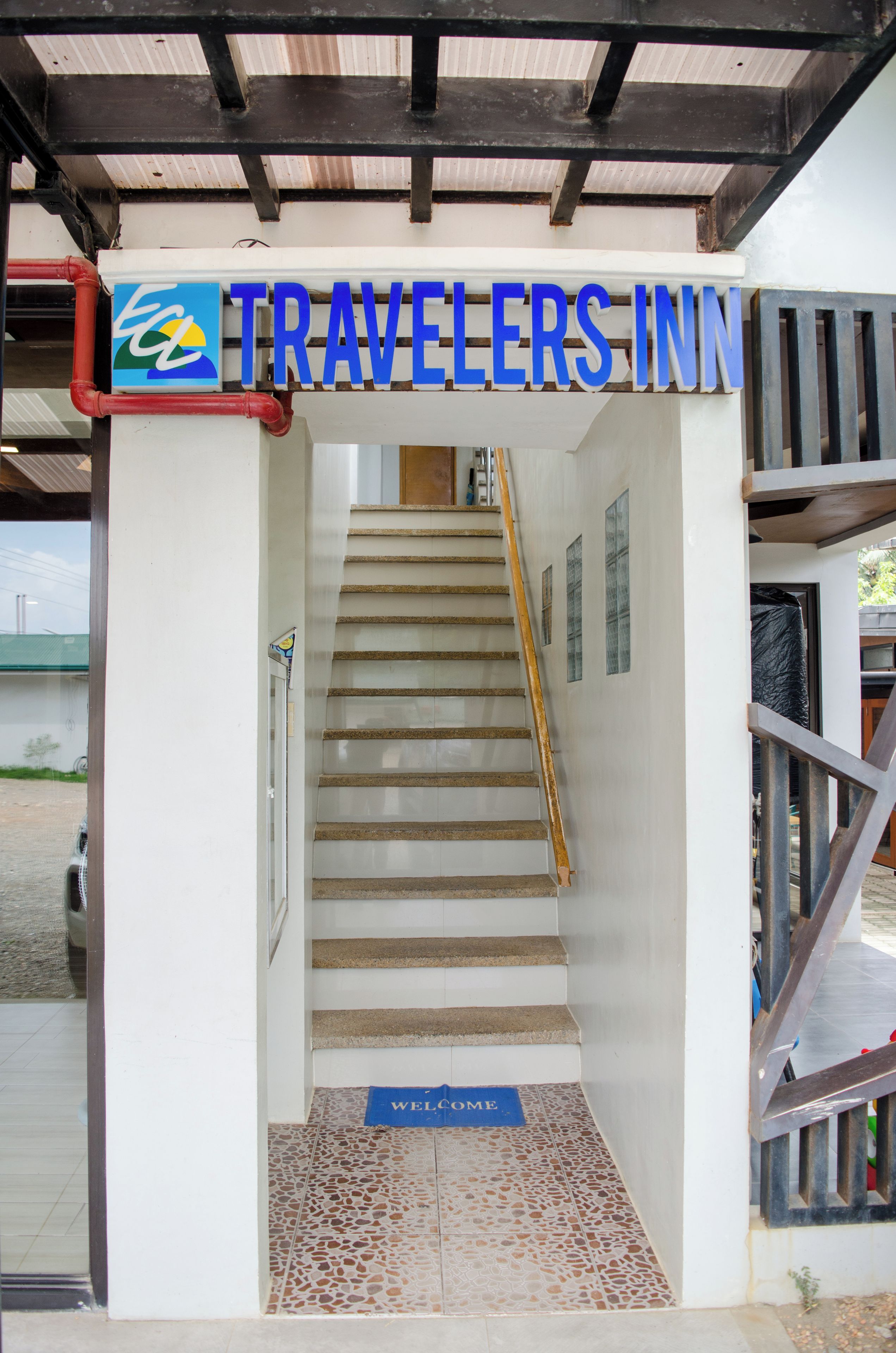 A staircase leading to a room with a sign reading 'TRAVELERS INN' above it.