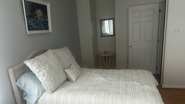 Una camera da letto con un letto, un tavolino, uno specchio e una porta.