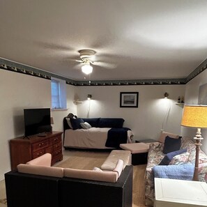 Ein Schlafzimmer mit einem Bett, einem Schminktisch, einem Fernseher, einem Deckenventilator und einer Lampe.