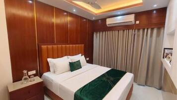 Quarto de hotel com cama, mesa de cabeceira e ar condicionado.