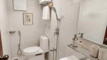 Un bagno moderno con toilette, bidet, doccia e lavandino.