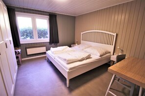 A bedroom with a bed, a desk, and a window. - Modernly Furnished Double Bungalow With Terrace in the Mirow Holiday Park (Mirow)