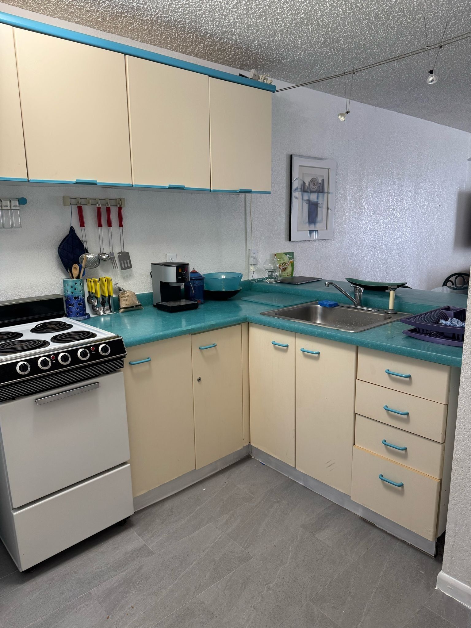 A kitchen with a stove, sink, and cabinets.