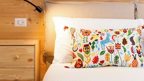 Una parete di legno con un letto, un comodino e una lampada.