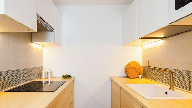 Una cucina moderna con isola centrale, due lavelli e cappa aspirante.