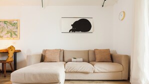Un soggiorno con un divano, una mappa appesa al muro e una sveglia.