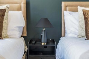 A hotel room with two beds, a nightstand with a lamp, and a drawer. - Spacious Twin Studio with Parking | Coventry CV2 (Coventry)