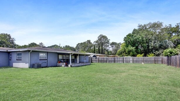 A residential property with a two-story house, a fenced backyard, and a clear sky. - Jax and Relax: 3-bedroom house in Jacksonville (Jacksonville)