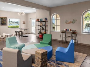A spacious living area with a high ceiling, a central seating arrangement, a bar area, and a view through large windows. - Marriott's Frenchman's Cove 2 Bedroom Villa (St Thomas)