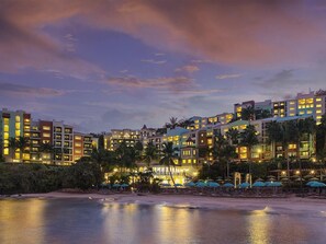 A beachfront hotel with multiple buildings, palm trees, and beach umbrellas. - Marriott's Frenchman's Cove 2 Bedroom Villa (St Thomas)