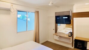 A hotel room with a bed, a TV, a window, and a ceiling fan. - VelaaOlhu - Turtle Hive Thulusdhoo (Thulusdhoo Island)