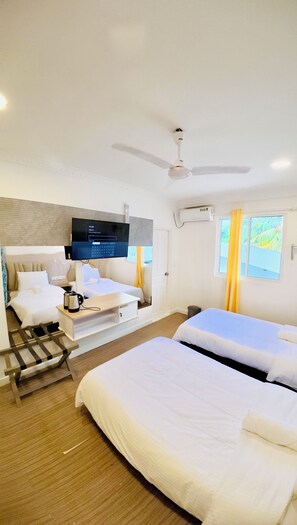 A hotel room with two beds, a television, a ceiling fan, and a window with curtains. - VelaaOlhu - Turtle Hive Thulusdhoo (Thulusdhoo Island)