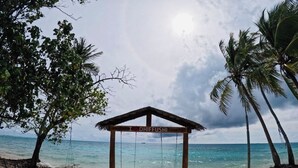 A beach scene with a wooden swing set and a sign that reads 'I ♥ DHIFFUSHI'.