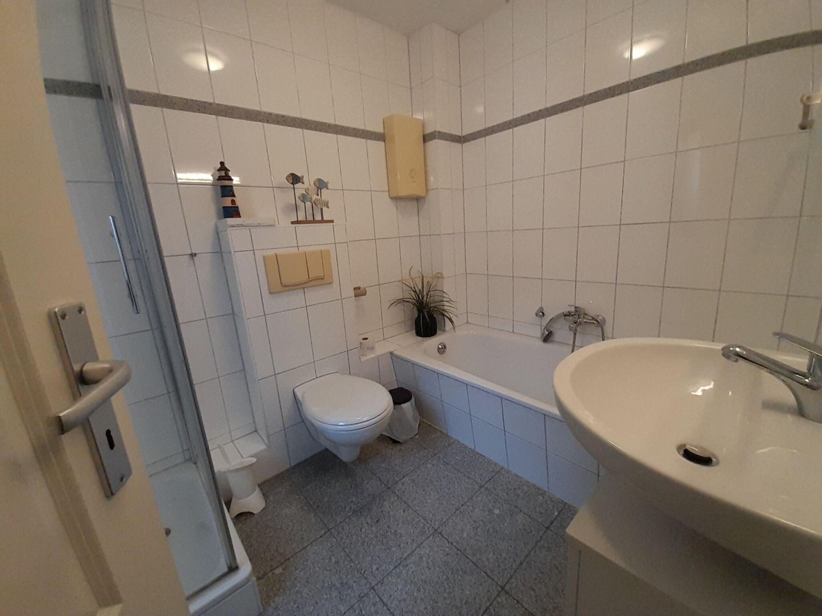 A bathroom with a toilet, sink, and bathtub.