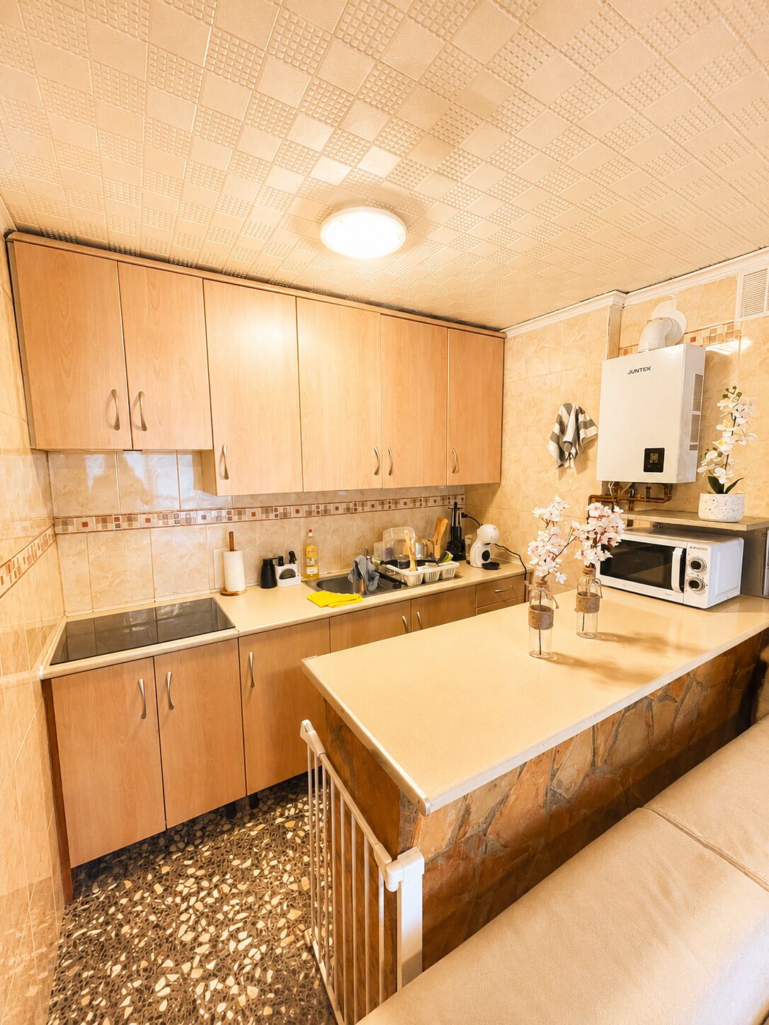A kitchen with wooden cabinets, a built-in microwave, and a stone countertop.