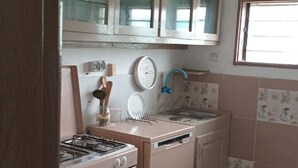 Una cocina con estufa a gas, horno y gabinetes.