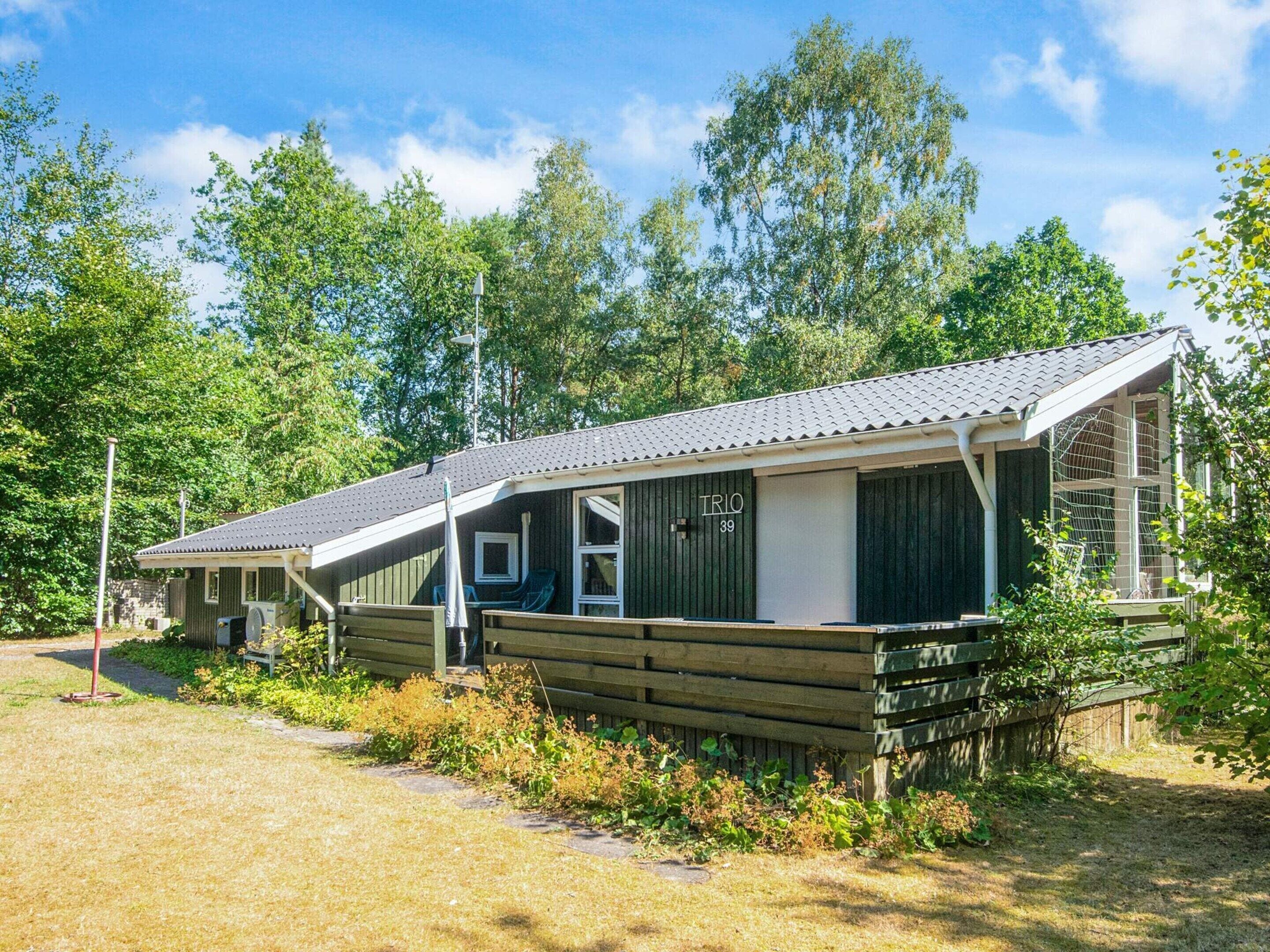 A row of cabins with a covered porch, numbered 39, surrounded by trees.