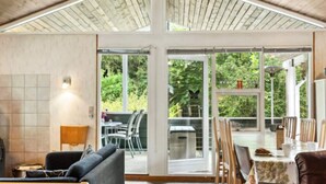 A spacious room with a high ceiling, large windows, and a view of greenery outside. - 8 Person Holiday Home in Ans By (Ans)